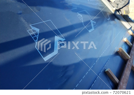 The worker stapler attaches to the rafter gidrobarier on the background can see the sky The worker stapler attaches to the rafter gidrobarier on the background can see the sky 72070621