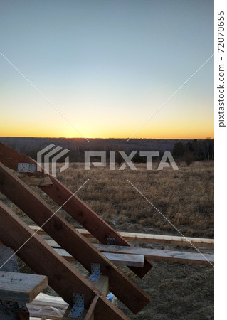 Wooden roof with rafter style framing against a blue sky 72070655