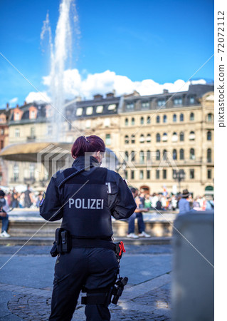 policewoman on patrol in the city streets 72072112