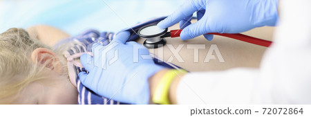 Doctor listens to little girl breathing with stethoscope. Doctor listens to little girl breathing with stethoscope. 72072864