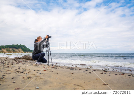 Female photographer shooting waving sea 72072911