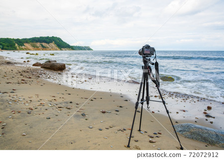 Photo camera on seashore on stormy day 72072912
