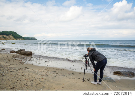 Unrecognizable photographer shooting waving sea 72072914