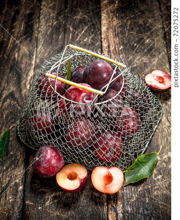 Fresh plums in a mesh bag. 72075272