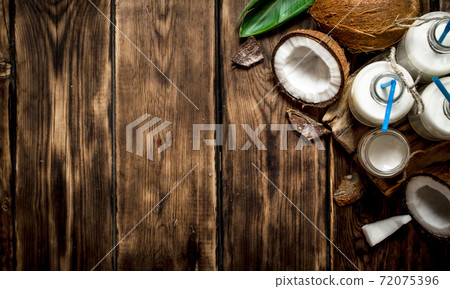 Coconut milk in bottles. 72075396