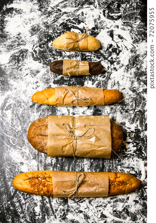 Set of fresh bread wrapped in paper. 72075955