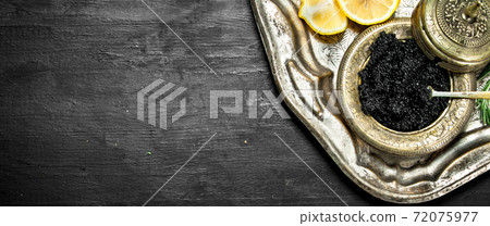 Black caviar with white wine on the old tray. Black caviar with white wine on the old tray. 72075977