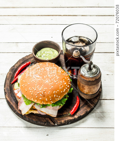Fresh burger with cola on a wooden board. Fresh burger with cola on a wooden board. 72076038