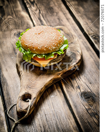 delicious Burger with meat , cheese and vegetables on wooden Board. delicious Burger with meat , cheese and vegetables on wooden Board. 72076071
