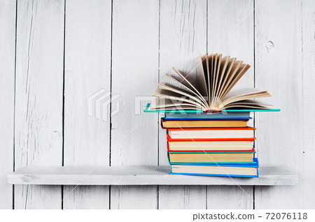 The open book on other multi-coloured books. The open book on other multi-coloured books. 72076118
