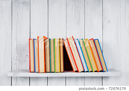 Books on a wooden shelf. Books on a wooden shelf. 72076170