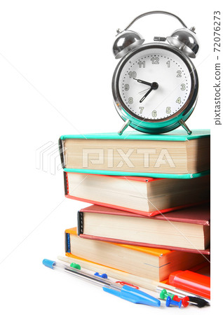 Books, an alarm clock and school tools. 72076273