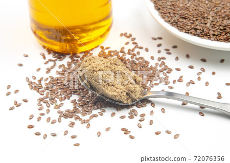 ground flaxseed and oil on white background. vitamins and healthy food 72076356