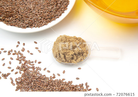 ground flaxseed and oil on a white background. vitamins and healthy food ground flaxseed and oil on a white background. vitamins and healthy food 72076615
