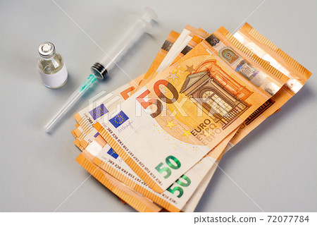 A stack of money and vaccine, medicine and syringe on a gray background 72077784