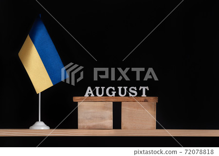 Wooden calendar of August with Ukrainian flag on black background. Dates in Ukraine in August Wooden calendar of August with Ukrainian flag on black background. Dates in Ukraine in August 72078818