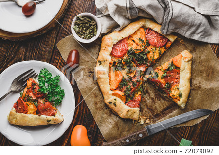 Sliced tomato galette on baking paper 72079092