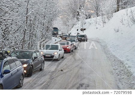 Road car congestion after snowfall in the Alps 72079598