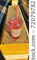 A cool drink on a yellow road, a pink packaged drink, a red cool drink. 72079782