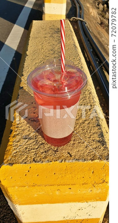 A cool drink on a yellow road, a pink packaged drink, a red cool drink. A cool drink on a yellow road, a pink packaged drink, a red cool drink. 72079782
