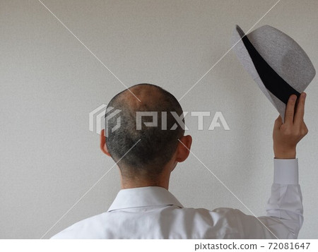 A man with thin hair and a shaved head takes off his hat and greets you. A man with thin hair and a shaved head takes off his hat and greets you. 72081647