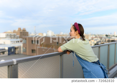 Housewife looking out from the balcony Housewife looking out from the balcony 72082810