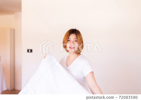 Make a bed,Asian women making her bed in room after wake up 72083580