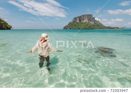 Asian woman standing and playing in the sea and enjoying with beautiful nature in her vacation. Summer holidays and travel concept. Travelling in Thailand. Asian woman standing and playing in the sea and enjoying with beautiful nature in her vacation. Summer holidays and travel concept. Travelling in Thailand. 72083947