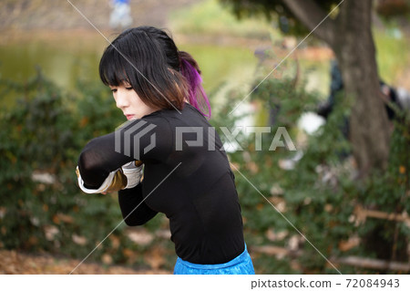 Woman training in martial arts in the park 72084943