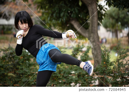 Woman training in martial arts in the park 72084945