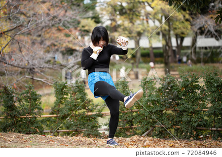 Woman training in martial arts in the park 72084946