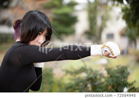 Woman training in martial arts in the park 72084948
