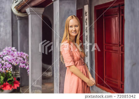 Woman tourist on background of Temple Ngoc Son in Hanoi, Vietnam.Temple of Literature is also called temple of Confucius. Vietnam reopens after coronavirus quarantine COVID 19 72085342