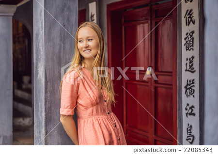 Woman tourist on background of Temple Ngoc Son in Hanoi, Vietnam.Temple of Literature is also called temple of Confucius. Vietnam reopens after coronavirus quarantine COVID 19 72085343