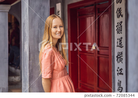 Woman tourist on background of Temple Ngoc Son in Hanoi, Vietnam.Temple of Literature is also called temple of Confucius. Vietnam reopens after coronavirus quarantine COVID 19 72085344
