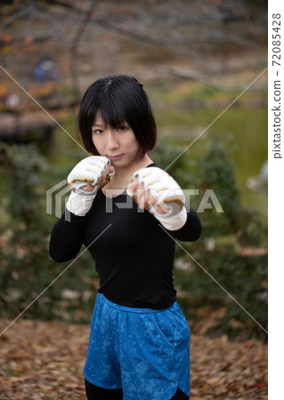 Woman in fighting pose in the park 72085428