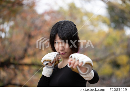Woman in fighting pose in the park 72085429