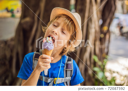 Cute child eating rabbit ice cream outdoors Cute child eating rabbit ice cream outdoors 72087392