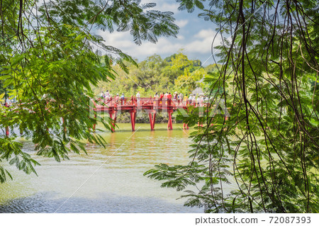 The Red Bridge in public park garden with trees and reflection in the middle of Hoan Kiem Lake in Downtown Hanoi. Urban city at sunset, Vietnam. Cityscape background The Red Bridge in public park garden with trees and reflection in the middle of Hoan Kiem Lake in Downtown Hanoi. Urban city at sunset, Vietnam. Cityscape background 72087393