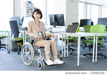 Portrait of a woman in a wheelchair smiling in the office 72088280