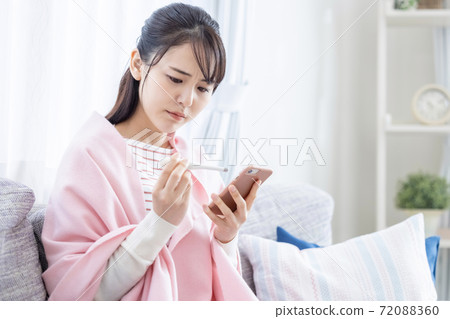 Poor physical condition: A young woman who measures body temperature Poor physical condition: A young woman who measures body temperature 72088360