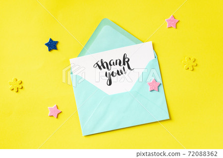 Thank You card in a teal blue envelope, shot from above on a yellow background Thank You card in a teal blue envelope, shot from above on a yellow background 72088362