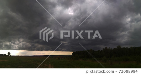 On the horizon there are stormy clouds over the meadow 72088984