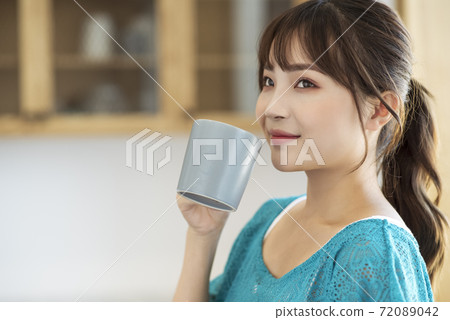 A young woman drinking coffee A young woman drinking coffee 72089042