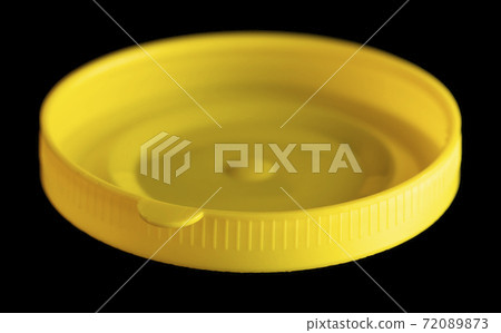 Yellow plastic jar lid isolated on black background. Yellow plastic jar lid isolated on black background. 72089873