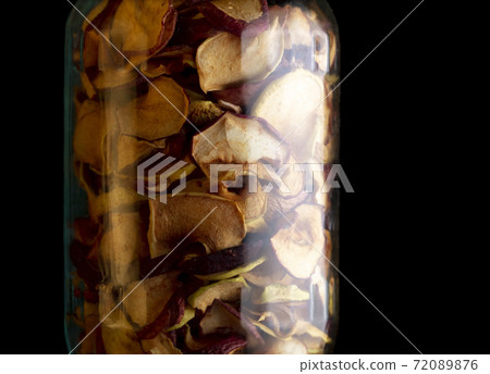 Dried apples in a jar on a black background. Dried apples in a jar on a black background. 72089876