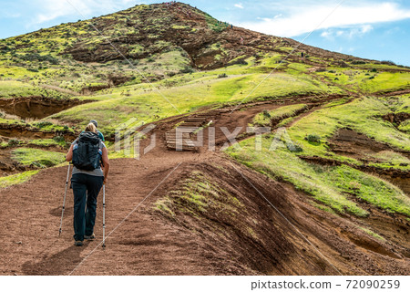 Girl hiking rocky cliffs clear near water of Atlantic Ocean bay Ponta de Sao Lourenco, the island of Madeira, Portugal 72090259