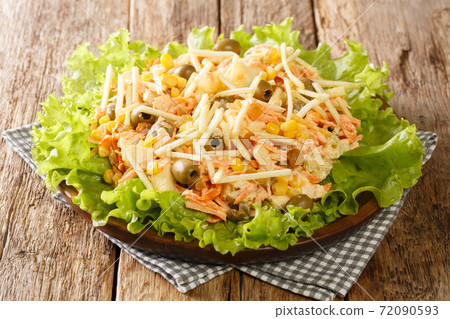 Serving of homemade Salpicao salad of chicken, vegetables, raisins, olives and potato sticks close-up on the table. horizontal 72090593