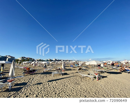 Unidentifiable people in the late afternoon on Caorle beach in Veneto, Italy 72090649
