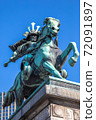 A statue of Masanari Kusunoki on horseback in the outer garden of the Tokyo Imperial Palace. Diagonal front angle. Oblique light. The background is a blue sky and a part of a building in the Marunouchi area. 72091897
